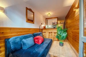 a living room with a blue couch and a table at Ski in and out heart of Val Thorens - 1BR Sleeps 4 people in Val Thorens +2 photos