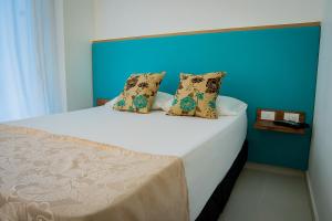 a bedroom with a large bed with a blue wall at La Puerta del Ángel LOW COST in Ricaurte