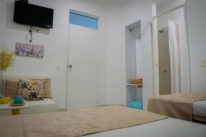 a bedroom with a bed and a tv on the wall at La Puerta del Ángel LOW COST in Ricaurte