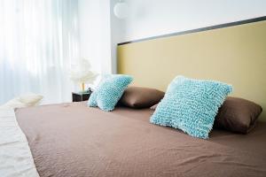 a bed with two blue pillows on top of it at La Puerta del Ángel LOW COST in Ricaurte