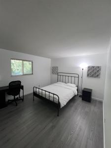 a bedroom with a bed and a desk and a lamp at Cozy Home near Downtown, UBC and YVR airport in Vancouver