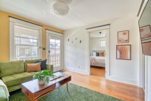 a living room with a green couch and a table at Overlook Gem - Steps from Mississippi in Portland