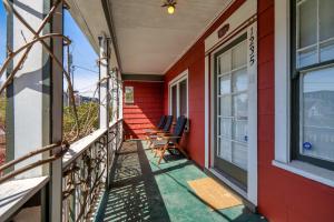 a porch of a red house with chairs on it at Overlook Gem - Steps from Mississippi in Portland