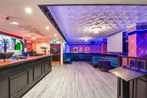 a bar with purple and blue walls and a stage at Albion Hotel in Auckland