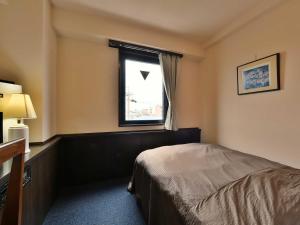a hotel room with a bed and a window at Suzuka Royal Hotel in Suzuka