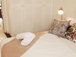 a bed with two towels sitting on top of it at Akamao in Grand-Bourg +11 photos