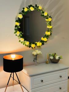 a wreath on a wall with a television on a dresser at Large Room Near City Centre in Belfast