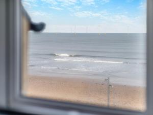 a view of the ocean from a window of a beach at Sea View Penthouse - Regency Mansion in Redcar +24 photos