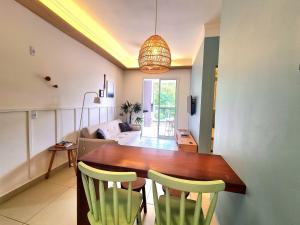 Un comedor y una sala de estar con mesa y sillas. en Apartamento Ubatuba 405, en Ubatuba