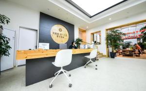 a person sitting at a counter in a restaurant at 笑脸里青年旅舍宽窄店 in Chengdu