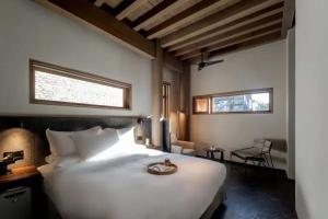 a bedroom with a large white bed and a chair at Dali Ancient City Xishan Designer Hotel in Dali Ancient Town