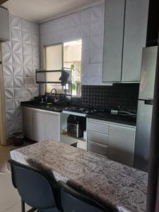 a kitchen with white cabinets and a table with chairs at Quarto casal privativo in Cuiabá