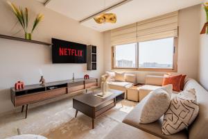a living room with a couch and a tv at CMN 5 min - Pool - self check-in in Nouaseur