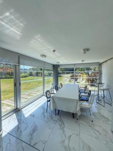 une salle à manger avec une table, des chaises et des fenêtres dans l'établissement Torre Bellagio - Piso 17 - Full Amenities - 4 Pax - Piscina Climatizada, à Punta del Este