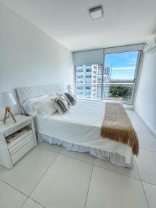 une chambre blanche avec un lit et une grande fenêtre dans l'établissement Torre Bellagio - Piso 17 - Full Amenities - 4 Pax - Piscina Climatizada, à Punta del Este 70 autres photos