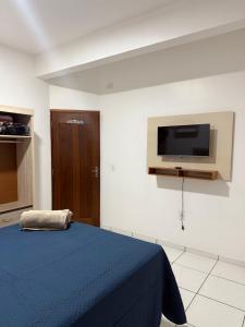 Un dormitorio con una cama y un televisor en la pared. en Apartamento Mobiliado, en Santarém