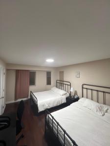 a room with two beds and a table and chairs at Cozy Home near Downtown, UBC and YVR airport in Vancouver +2 photos