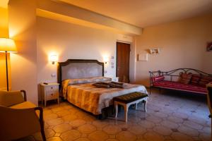 a bedroom with a bed and a bench in it at Tenuta Del Perugino in Bettona +67 photos