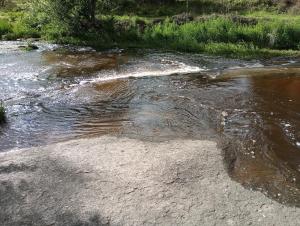 a stream of water with rocks and grass on the side at Casa Cali in Tanti Nuevo
