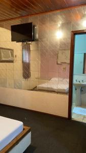 a room with a glass window with a bed and a sink at Motel Casa Branca in Blumenau +82 photos