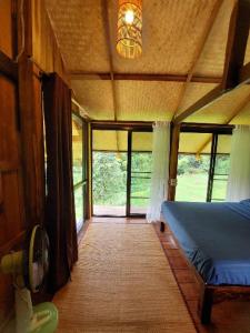 a bedroom with a bed in a room with windows at KowitFarmstay in Ban Mae Pan Noi