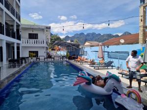 a woman laying on a raft in a swimming pool at Santara Hostel in Vang Vieng