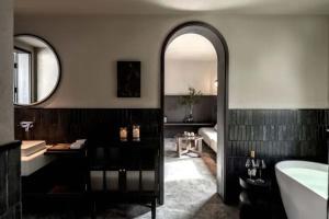 a bathroom with a tub and a sink and a mirror at Dali Ancient City Xishan Designer Hotel in Dali Ancient Town +88 photos