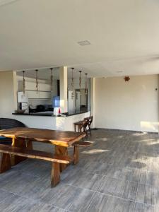 Habitación vacía con mesa de madera y cocina en Vivenda da Alegria, en Vera Cruz de Itaparica 4 fotos más