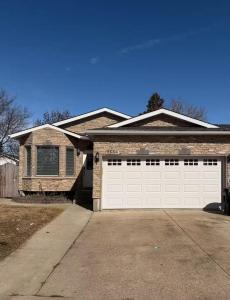 een stenen huis met een witte garagedeur bij Peaceful- King Beds- Attached Garage - Pet Friendly in Edmonton