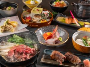 a table topped with plates of food and bowls of food at Izumigo Takayama Dog Paradise Hotel in Takayama +56 photos
