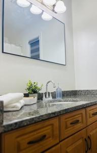 een badkamermeubel met een wastafel en een spiegel bij Peaceful- King Beds- Attached Garage - Pet Friendly in Edmonton