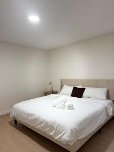 een slaapkamer met een groot wit bed met witte lakens bij Peaceful- King Beds- Attached Garage - Pet Friendly in Edmonton