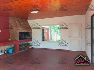 Una sala de estar con chimenea de ladrillo y una ventana. en Villa Armonia, en La Picada
