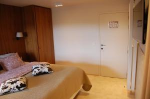 a hotel room with a bed and a door at B&B Cottage Sandfort in Zandvoorde