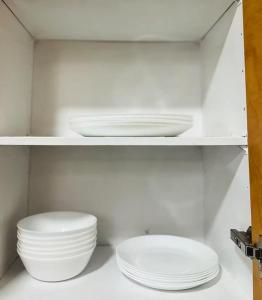 twee witte kommen en borden op een plank bij Peaceful- King Beds- Attached Garage - Pet Friendly in Edmonton