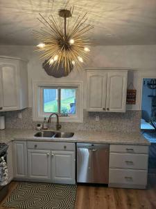 Il dispose d'une cuisine avec un évier et un lustre. dans l'établissement 4 Bedrrom Downtown Gem, Modern, Comfort, Fireplace, Huge Backyard, Steps to Lake and Broadwalk, à Temiskaming Shores