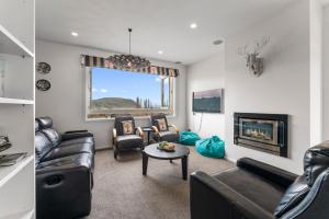 a living room with leather furniture and a fireplace at Kinloch Lookout in Kinloch
