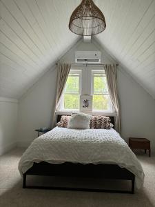 une chambre avec un grand lit avec une fenêtre dans l'établissement 4 Bedrrom Downtown Gem, Modern, Comfort, Fireplace, Huge Backyard, Steps to Lake and Broadwalk, à Temiskaming Shores