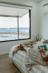 a bedroom with a bed with a view of the beach at Stones Throw - Brand New Beach House in Stokes Bay