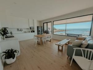 a kitchen and living room with a view of the ocean at Stones Throw - Brand New Beach House in Stokes Bay