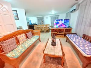 een woonkamer met twee banken en een tv bij Panglao Ramyer Villa 1 in Sampong