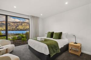 une chambre avec un lit et une grande fenêtre dans l'établissement Lakefront Luxury 3 Bedroom Apartment, à Wanaka