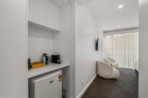 une cuisine avec des murs blancs et une chaise blanche dans l'établissement Lakefront Luxury 3 Bedroom Apartment, à Wanaka