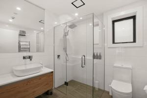 une salle de bain blanche avec lavabo et douche dans l'établissement Lakefront Luxury 2 Bedroom Apartment, à Wanaka