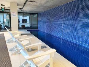 a room with a swimming pool with chairs in it at VAQUAY Embassy In Abbotsford in Melbourne