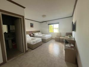 ein Wohnzimmer mit zwei Betten und einer Couch in der Unterkunft Csm Clark Hotel in Pampang