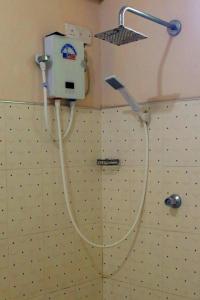 a shower with a hose attached to a wall at Unaway Holiday Home in Unawatuna +21 photos