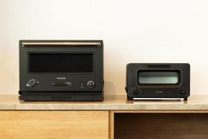 Asnova Resort FLORES ATAMI في أتامي: يوجد ميكروويف وفرن محمص على منضدة