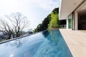 an infinity pool in the backyard of a house at Asnova Resort FLORES ATAMI in Atami