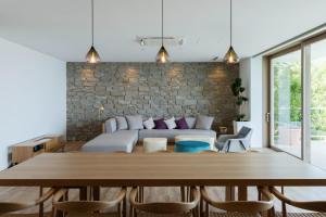 Asnova Resort FLORES ATAMI في أتامي: غرفة بسرير وطاولة وكراسي